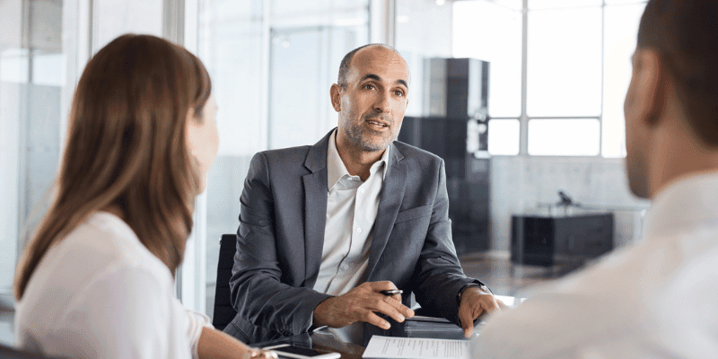 A financial advisor and two customers discussing at a table