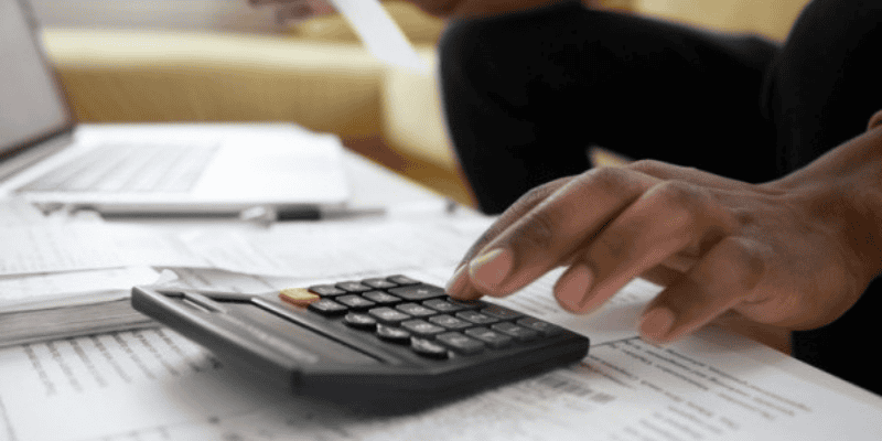 A closeup of a hand using a calculator