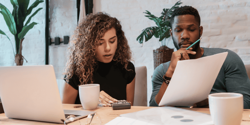 A couple planning finances by computers and papers